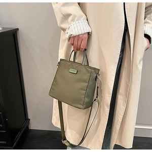 Détail du sac cabas en nylon vert olive avec large bandoulière et patch lettrage