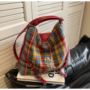 Detailed close-up of retro plaid pattern with red leather trim and silver metal MR logo