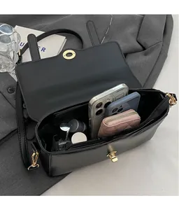 Vue intérieure du sac bandoulière noir montrant un grand espace pour téléphones et portefeuille