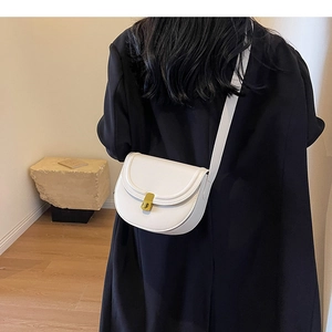 Detailed back view of a white leather saddle bag with gold buckle on a model shoulder