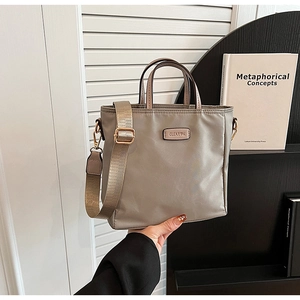 Détail du sac cabas en nylon taupe avec bandoulière large et logo CLEAROK de style urbain