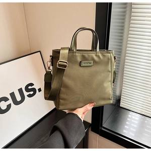 Détail du sac en nylon vert armée avec bandoulière large et finitions dorées