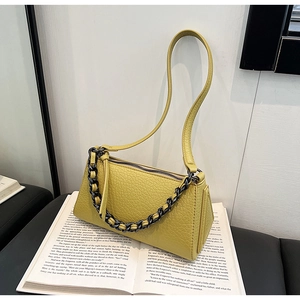 Detailed close-up of textured lime green faux leather bag with dark gunmetal chain strap