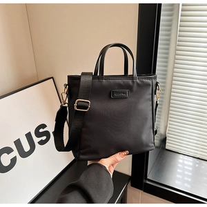 Détail du sac seau en nylon noir avec bandoulière large et finitions dorées CLEAROK