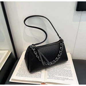 Detail of black pebbled leather texture bag with chunky silver metal chain strap