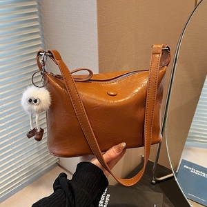 Brown oil wax leather bucket bag for women with cute white plush doll charm