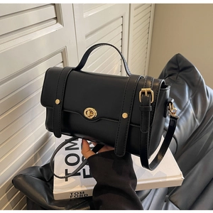 Détails d'un sac à main en cuir noir avec ferrures dorées et élégant rabat rectangulaire