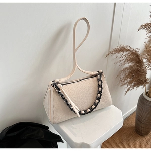 Detail of cream white leather bag with lychee texture and decorative thick chain