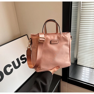 Gros plan du sac seau en nylon rose clair avec logo CLEAR K et bandoulière