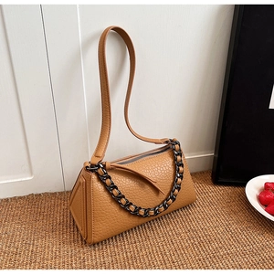 Close-up of caramel leather crossbody bag with textured finish and silver metal chain