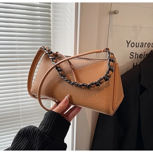 Detail of camel leather crossbody bag with pebble texture and chunky metal chain