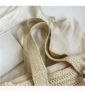Close-up of the woven straw tote bag featuring sturdy handles and soft fabric lining