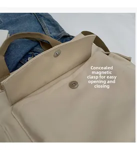 Detail of invisible magnetic buckle closure on a beige canvas tote bag with woven strap