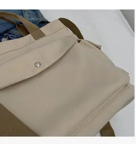 Detail of off-white canvas tote with brown woven handle and magnetic pocket button
