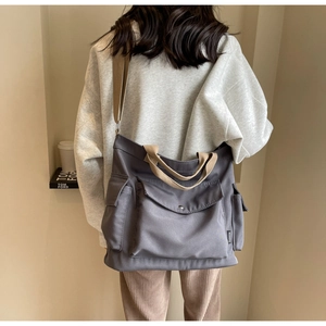 Detailed back view of a grey canvas tote bag with multi-pockets and khaki straps