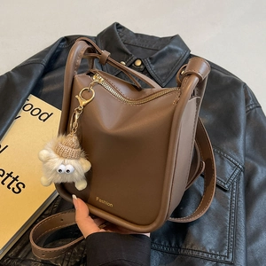 Retro dark brown leather bucket bag with gold hardware and cute plush charm detail