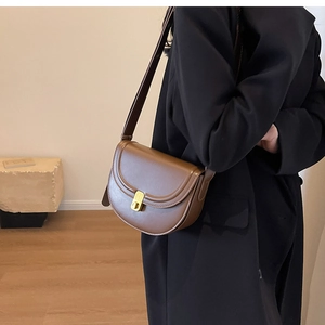 Brown vintage saddle bag with matte leather finish and gold metallic twist lock