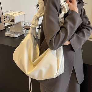 Sac fourre-tout plissé blanc crème minimaliste présenté dans un décor moderne