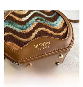 Detail of a brown lamb wool crossbody bag with wave texture and gold protective studs