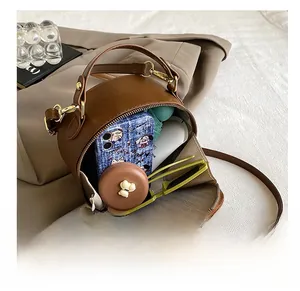 Interior view showing the storage capacity of this brown cylindrical crossbody bag