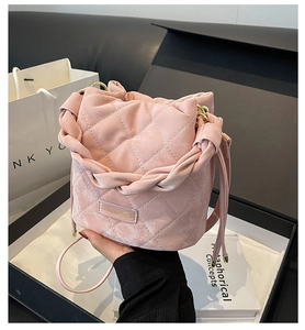 Detail der rosa gesteppten Wildleder Eimertasche mit Webgriff und goldenem Beschlag