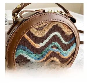 Close-up of retro round handbag showing woven texture and gold metal hardware detail
