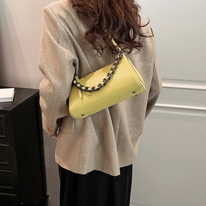 Lime green cylinder crossbody bag with pebble leather and metallic chain strap