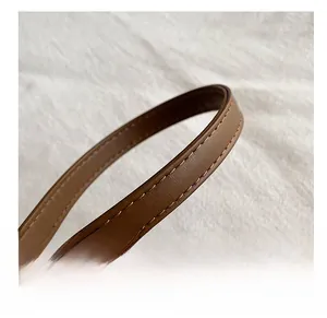Close-up of brown leather shoulder strap featuring detailed double stitching and high texture