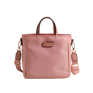 Sac seau rose en nylon avec bandoulière large et logo métallique de la marque