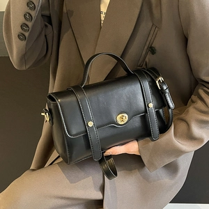 Sac carré élégant en cuir noir mat avec ferrures dorées et poignée supérieure
