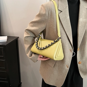 Minimalist mustard yellow crossbody bag with trendy triangle design and black chain strap