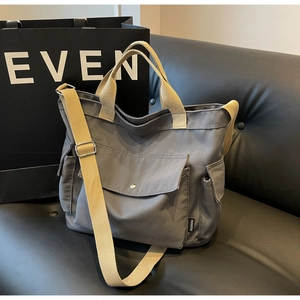 Detail of grey canvas tote bag with adjustable straps and front pocket