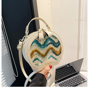 Detail of round beige crossbody bag with wavy fabric pattern and BOWEN logo print