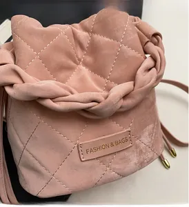 Detailansicht der rosa gesteppten Beuteltasche mit Flechtgriff und Mode-Logo-Etikett