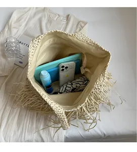 Spacious interior of beige straw tote bag with tassels showing large storage capacity