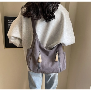 Détail du sac cabas en toile montrant le style de portage de dos et les poches