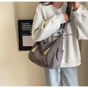 Détail du sac hobo en toile gris foncé avec poches zippées et large bandoulière réglable
