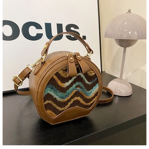 Detail of a round vintage leather crossbody bag featuring textured rainbow knit pattern