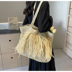Detail of bohemian straw tote bag with long tassels and woven texture for summer