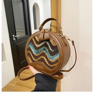 Detail view of the hand-held vintage mini round bag with woven pattern and leather strap