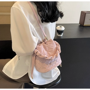 Detail einer rosa gesteppten Beuteltasche mit geflochtenem Griff und Kordelzug