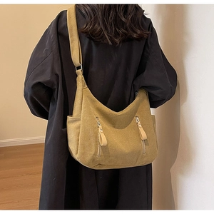 Détail macro du sac cabas en toile jaune moutarde avec deux poches zippées verticales