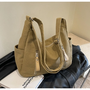 Détail du sac fourre-tout en toile jaune moutarde avec fermeture éclair et poches latérales