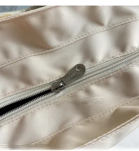 Detail of high-quality smooth metal zipper with Sunchao engraving on a beige canvas tote bag