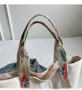 Detail of canvas tote bag featuring floral pattern ribbon handle and SIJI brand logo