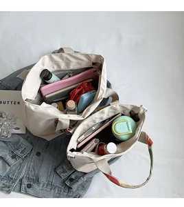 Detailed interior storage view of ivory canvas tote bags with colorful ethnic style straps