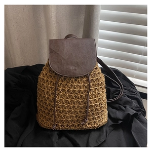 Detail of woven straw texture and leather drawstring closure on a travel backpack