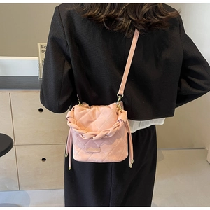 Detailansicht der rosa gesteppten Beuteltasche mit Webgriff am Modell getragen