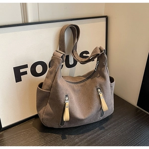 Détail du sac fourre-tout en toile marron avec poches zippées et bandoulière large