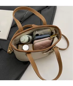 Top view of spacious beige bucket bag interior with compartments for phone and wallet